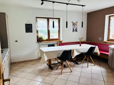 a kitchen with a table and chairs in a room at Ciasa Fam Comploi in San Vigilio Di Marebbe