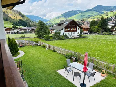 a table and chairs in a yard with a house at Ciasa Fam Comploi in San Vigilio Di Marebbe