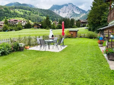 a patio with a table and chairs in a yard at Ciasa Fam Comploi in San Vigilio Di Marebbe