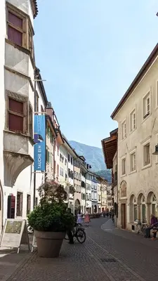 a city street with buildings and a person riding a bike at Erker Apartment in Bolzano