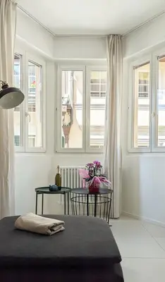 a white room with a table and windows at Erker Apartment in Bolzano