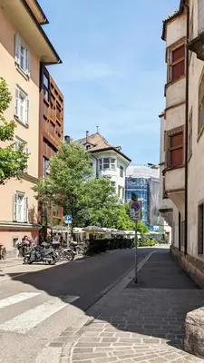 an empty street in a city with buildings at Erker Apartment in Bolzano