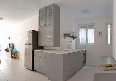 a large white kitchen with a refrigerator and cabinets at Erker Apartment in Bolzano