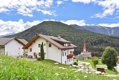 a house on a hill with mountains in the background at Fuchshof in Perca