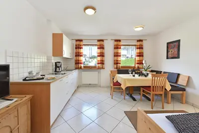 a kitchen and dining room with a table and chairs at Fuchshof in Perca