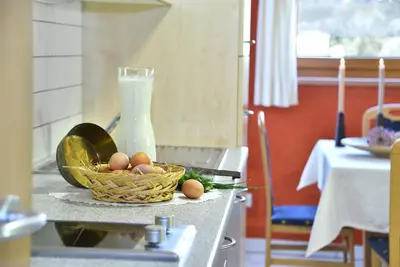 a basket of eggs on a counter with a bottle of milk at Fuchshof in Perca