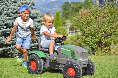 two young boys riding on a toy tractor at Fuchshof in Perca