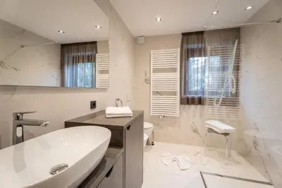 a bathroom with a sink and a tub and a toilet at Villa A - NEW OPENING in Selva di Val Gardena