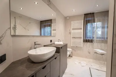 a white bathroom with a sink and a toilet at Villa A - NEW OPENING in Selva di Val Gardena