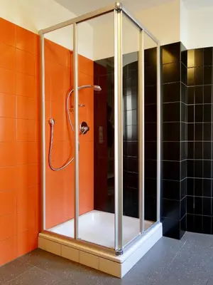 a shower in a bathroom with orange tiles at Gemütliches Studio mit Parkgarage in Naturno