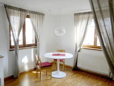 a white table and chairs in a room with windows at Gemütliches Studio mit Parkgarage in Naturno
