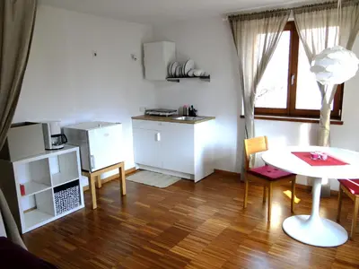 a living room with a table and a kitchen at Gemütliches Studio mit Parkgarage in Naturno