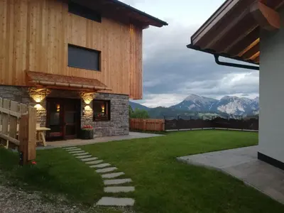 a house with a lawn and mountains in the background at Canalhof in Antermoia