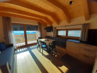 a kitchen and dining room with a table and chairs at Canalhof in Antermoia