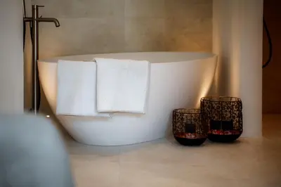 a white bath tub in a bathroom with two baskets at Anna Lodges Dolomites in Santa Cristina in Val Gardena