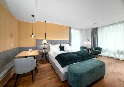a bedroom with a large bed and a table and chairs at Anna Lodges Dolomites in Santa Cristina in Val Gardena