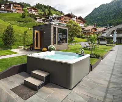 a hot tub on the patio of a house at Anna Lodges Dolomites in Santa Cristina in Val Gardena