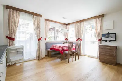 a kitchen with a table and chairs in a room at Apartment Romana in Selva di Val Gardena