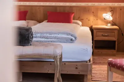 a bedroom with two beds with red pillows at Les Gomines BB***** in San Vigilio Di Marebbe