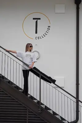a woman standing on the stairs of a building at T-Collection Premium Apartments in Vipiteno