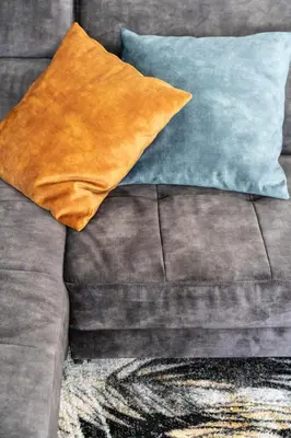 a brown couch with two pillows on it at T-Collection Premium Apartments in Vipiteno