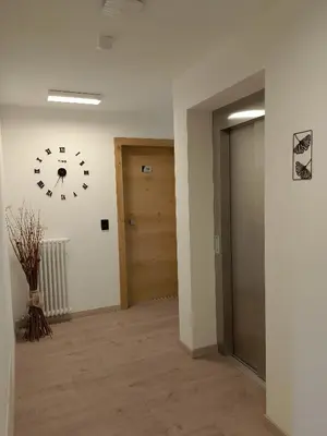 a hallway with a clock on the wall and a door at Agritur La Fenice in Brez
