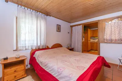 a bedroom with a bed and a wooden ceiling at Casa Morel in Falcade