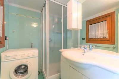 a bathroom with a sink and a washing machine at Casa Morel in Falcade