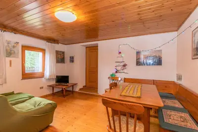 a living room with a table and a couch at Casa Morel in Falcade