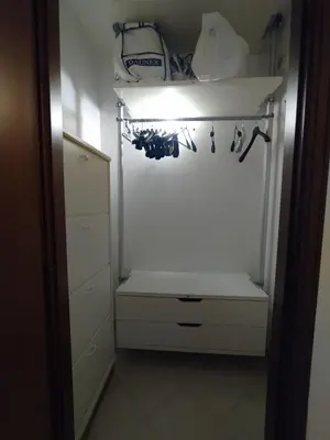 a closet with a white cabinet and a shelf at Pragma Apartments - Appartamento Dellantonio in Predazzo