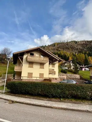 a house on the side of a street with a car at Pragma Apartments - Appartamento Dellantonio in Predazzo
