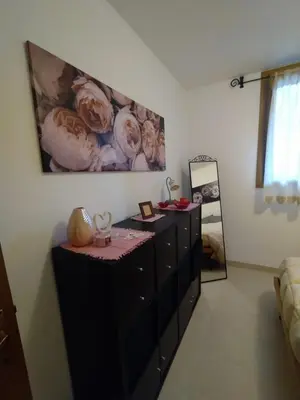 a room with a dresser with a painting on the wall at Pragma Apartments - Appartamento Dellantonio in Predazzo