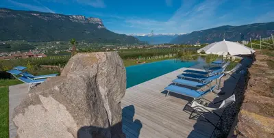 a group of chairs and an umbrella next to a pool at Lavendelhof in Appiano sulla Strada del Vino