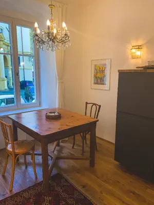 a dining room with a table and chairs and a chandelier at Palais Carducci in Bolzano