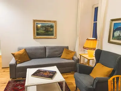 a living room with a couch and two chairs at Palais Carducci in Bolzano