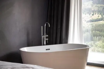 a bath tub in a room with a window at Alpuris - Your Boutique Suite - Hotel B&B in Cavalese