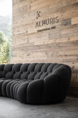 a row of seats in front of a sign on a wall at Alpuris - Your Boutique Suite - Hotel B&B in Cavalese