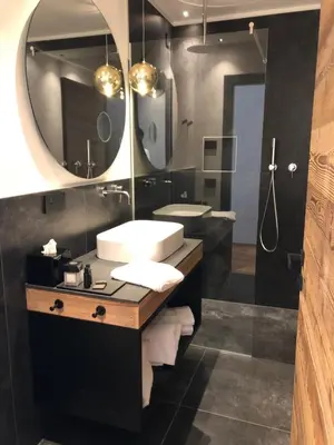 a bathroom with a sink and a mirror at Alpuris - Your Boutique Suite - Hotel B&B in Cavalese