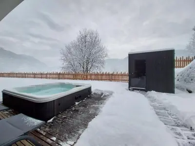 a hot tub in the snow with a fence at Alpuris - Your Boutique Suite - Hotel B&B in Cavalese
