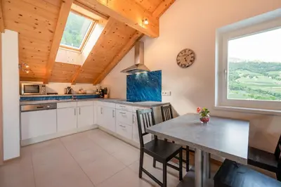 a kitchen with a table and a large window at Appartement Schusterhof in Gries