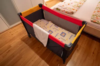 a crib with a blanket on it in a bedroom at Appartement Schusterhof in Gries