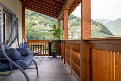 a porch with chairs and a view of a mountain at Appartement Schusterhof in Gries