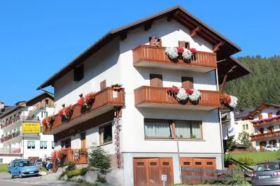 a mountain range with trees and mountains in the background at Hotel Cime d'Auta in Falcade