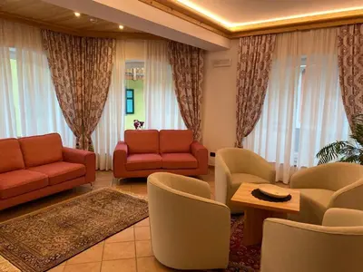 a living room with couches and chairs and a table at Garnì Villa Elsa in Pozza di Fassa