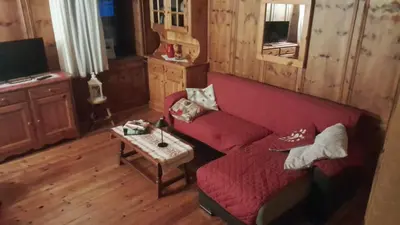 a living room with a red couch and a table at Appartamento GIRASOLE in Trodena