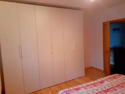 a bedroom with white cabinets and a bed at Appartamento GIRASOLE in Trodena