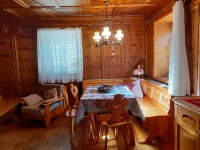 a dining room with a table in a log cabin at Appartamento GIRASOLE in Trodena