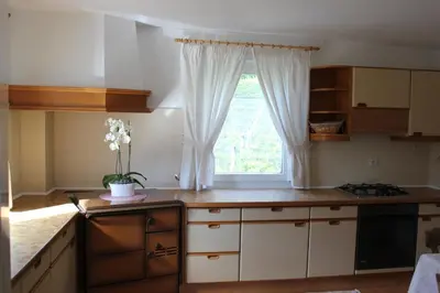 a kitchen with white cabinets and a window at Wiesenheim- Unterer Plattenhof 