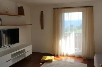 a living room with a television and a large window at Wiesenheim- Unterer Plattenhof 