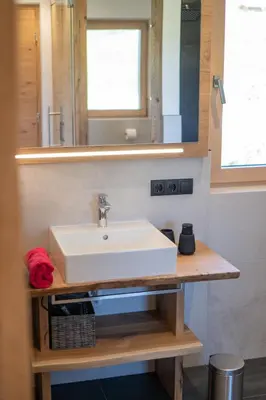 a bathroom with a white sink and a mirror at Chalet am Wiesenweg in Chiusa